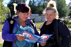 Deux femmes debout lisant une brochure