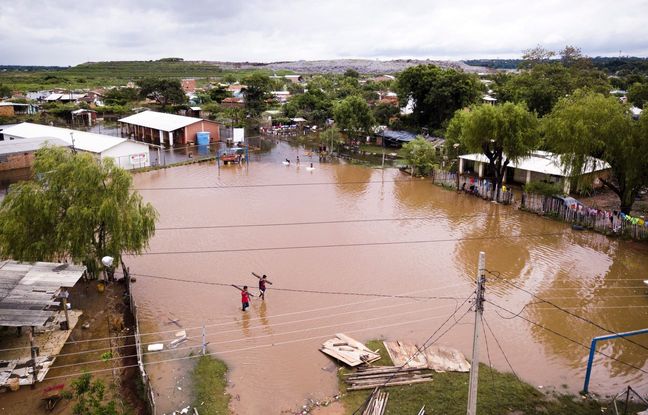 Des hommes portant des planches pataugent sur un terrain de football inondé dans le quartier de Jukyty, à Asuncion, au Paraguay, le 4 avril 2019. Plus de 20.000 personnes ont été évacuées après que des pluies torrentielles ont provoqué d’importantes inondations