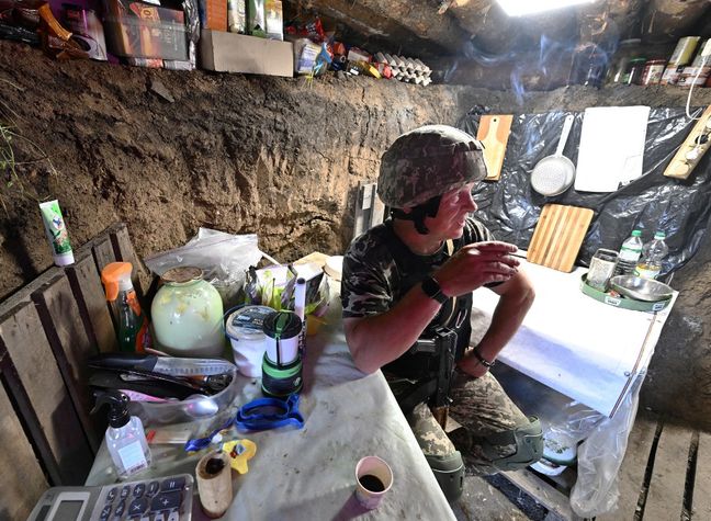 Le militaire ukrainien Andriy, 54 ans, se repose dans une tranchée sur une position occupée par l'armée ukrainienne entre les villes du sud de Mykolaïv et Kherson le 12 juin 2022.