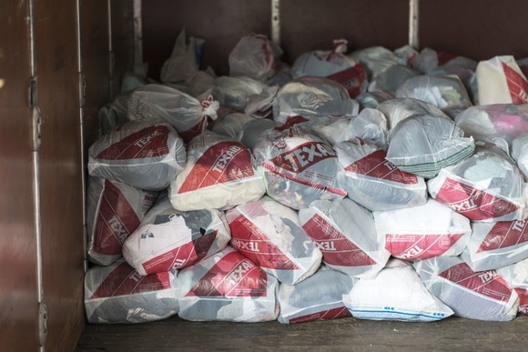 sacs de vêtements usagés Texaid empilés
