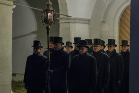 12 hommes vêtus de noir avec des chapeaux haut de forme