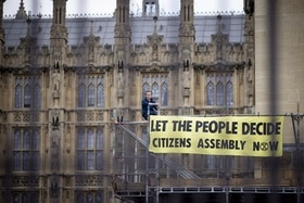 Activiste avec une banderole devant le Palais de Westminster