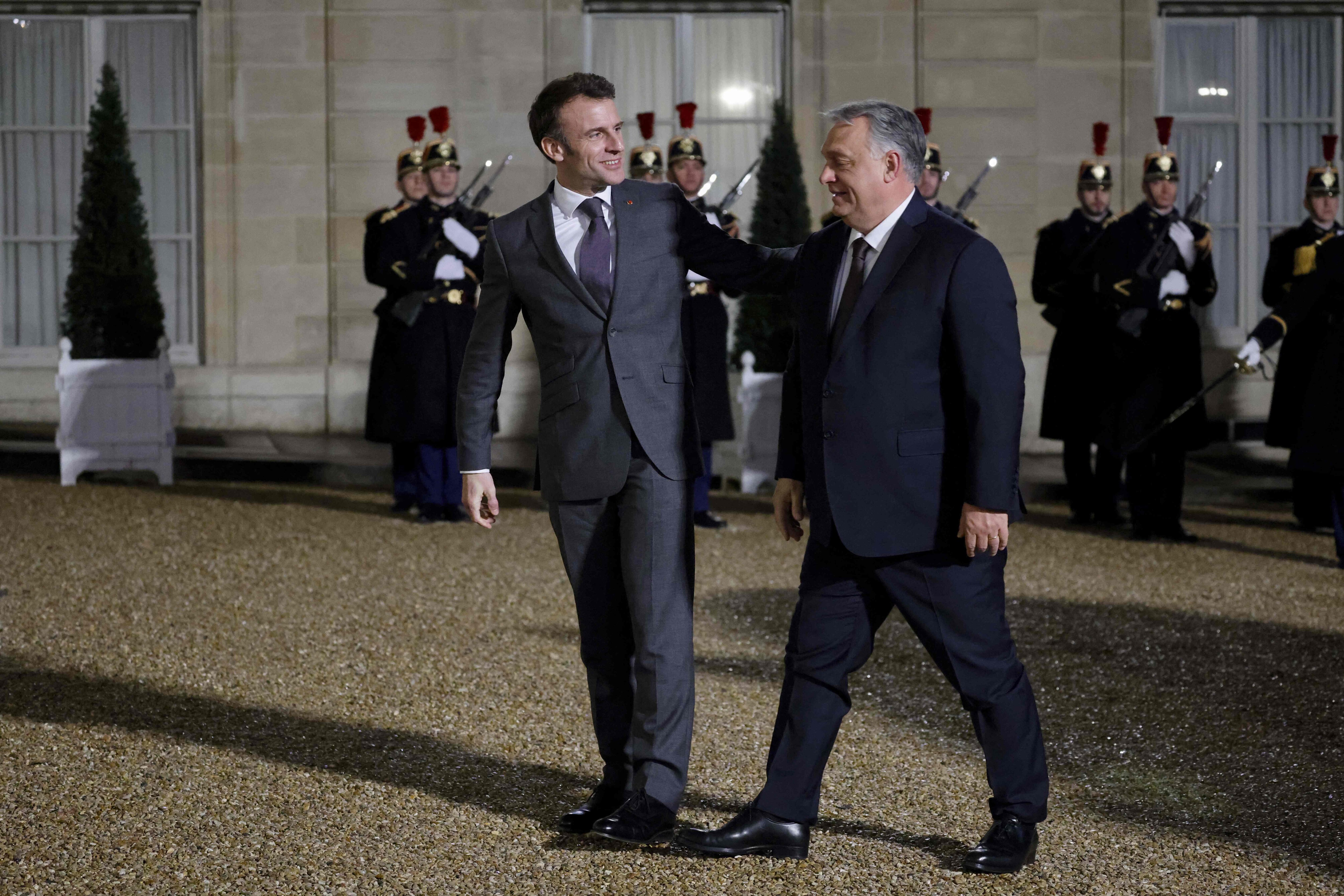 Fance's President Emmanuel Macron (C) welcomes Hungarian Prime Minister Viktor Orban (R), before a working dinner at the Elysee Presidential Palace in Paris on March 13, 2023. (Photo by Ludovic MARIN / AFP)