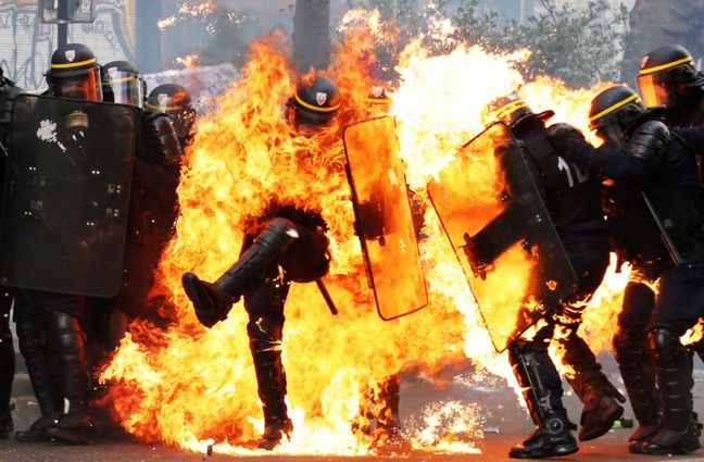 Des CRS engloutis par les flammes après le jet d'un coktail Molotov lors de la marche du 1er mai à Paris, le 1er mai 2017.