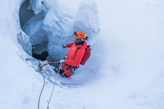 Homme debout face à l entrée d un glacier