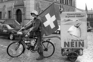 Homme en uniforme avec un drapeau sur un vélo