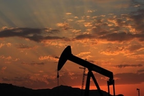 pompa petrolifera sullo sfondo di un cielo al tramonto