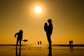 Un père sur un plage avec ses enfants