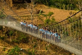 Des écoliers en uniforme sur un pont suspendu au Népal