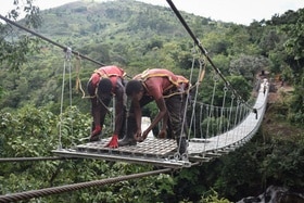 Deux hommes construisent un pont suspendu