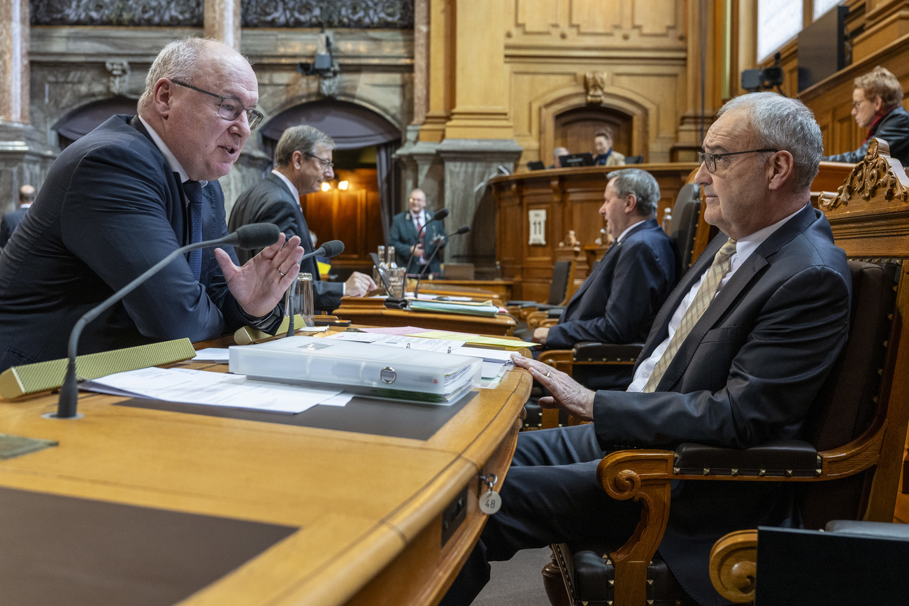 Deux hommes en train de discuter au parlement suisse.