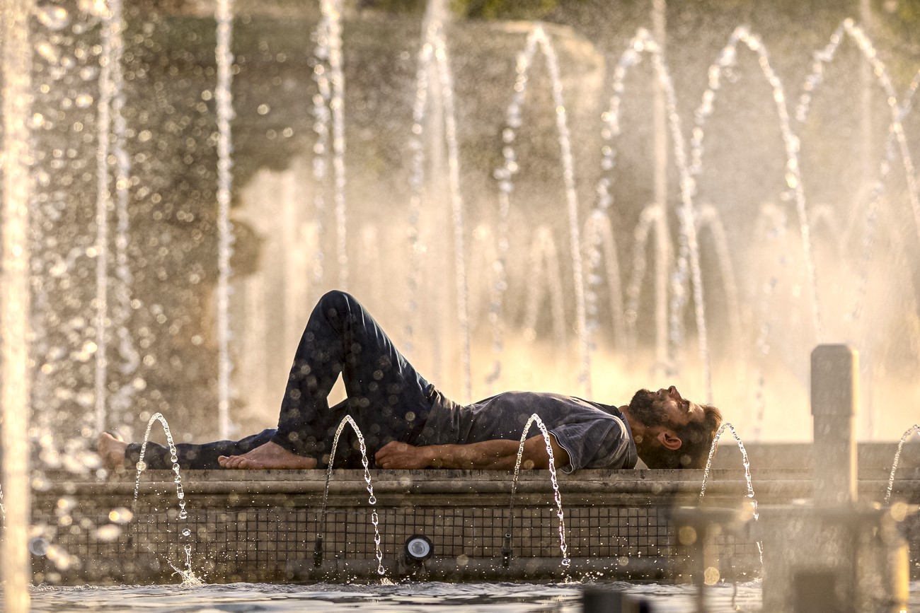 Homme étendu devant des jets d'eau