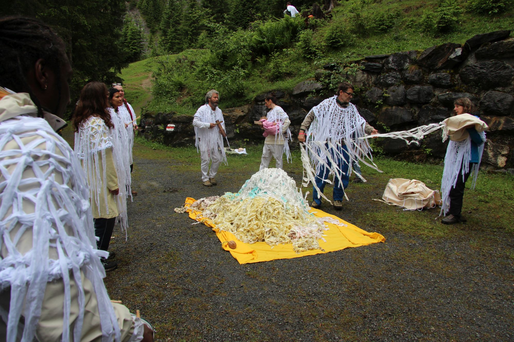 Groupe de personnes autour d'une œuvre d'art en plein air.