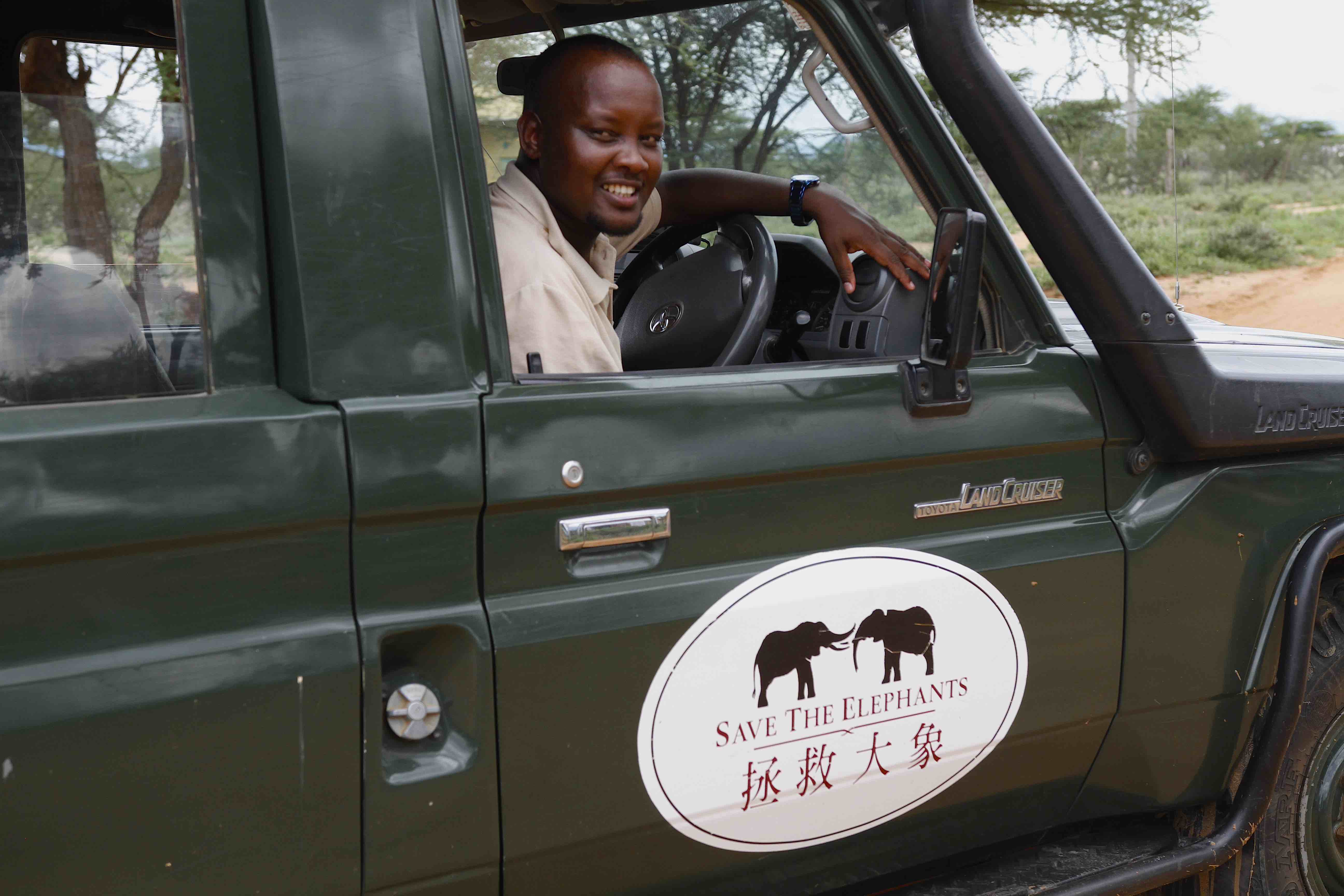 Homme noir au volant d'un véhicule rouge au Kenya