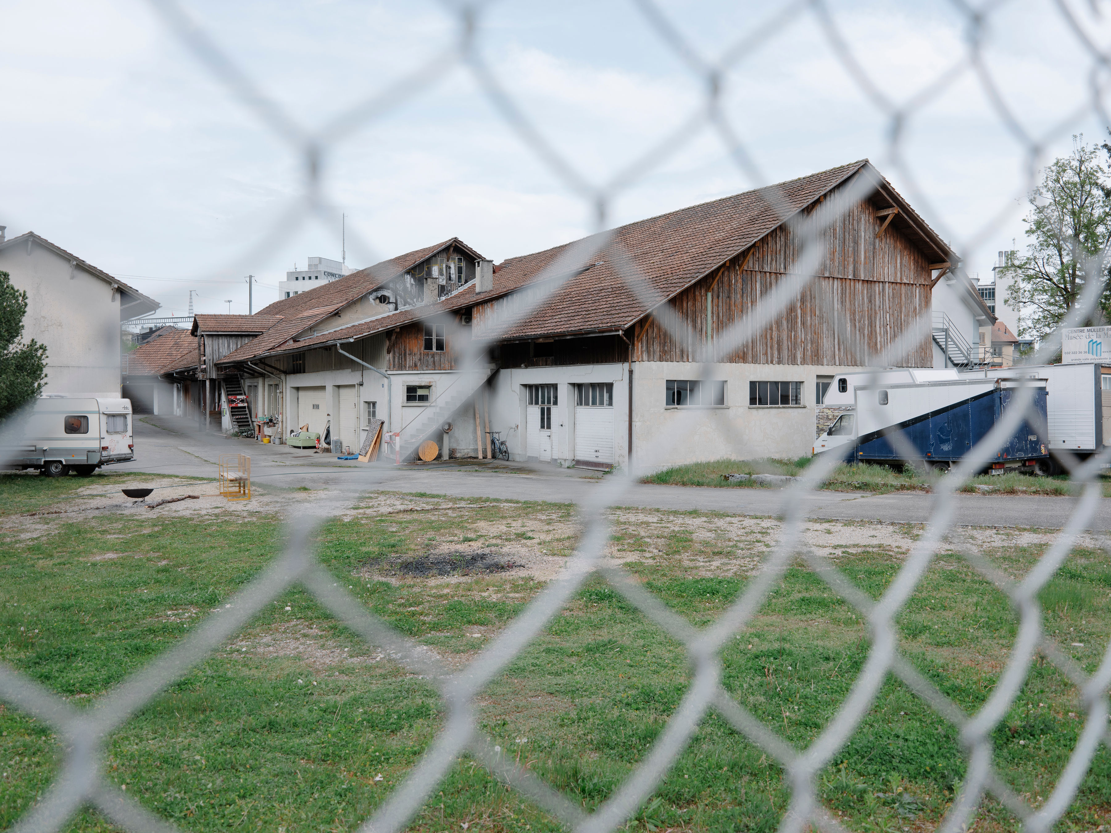 Vue sur des baraquements à travers un treillis