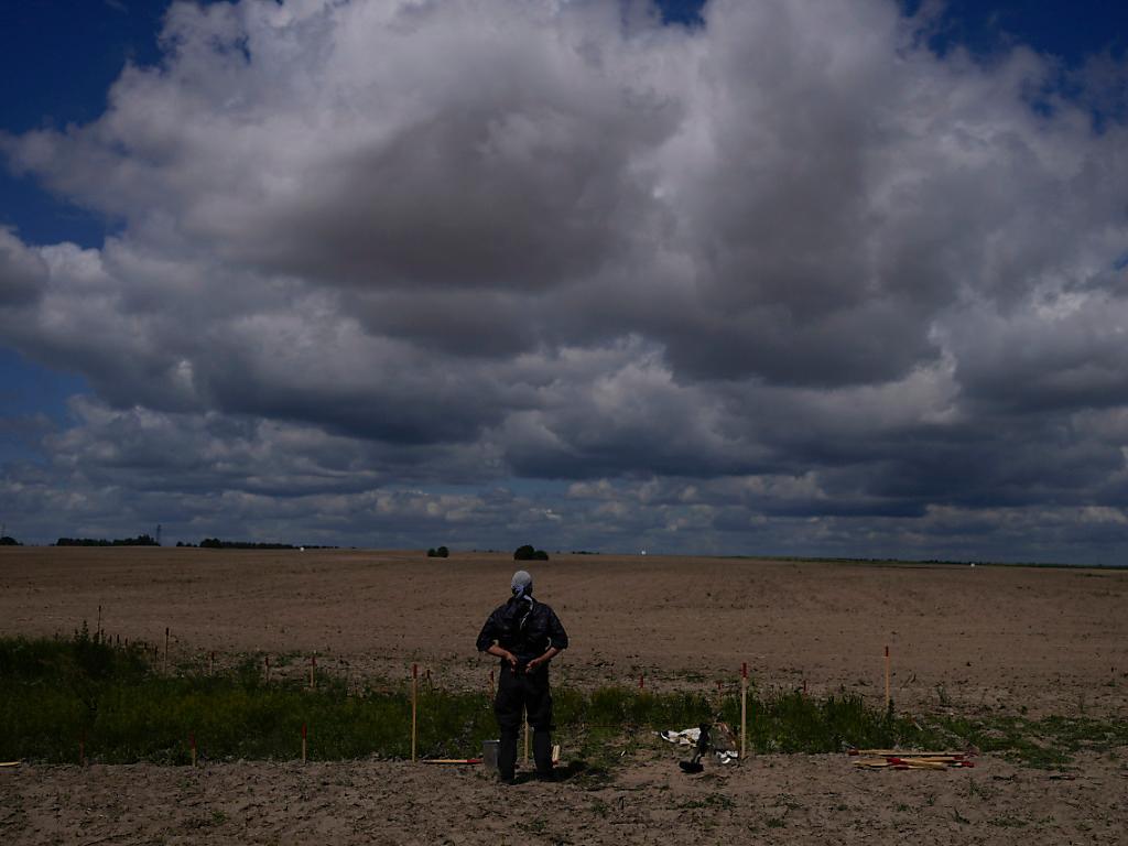 Démineur à côté d'un champ sous un ciel nuageux