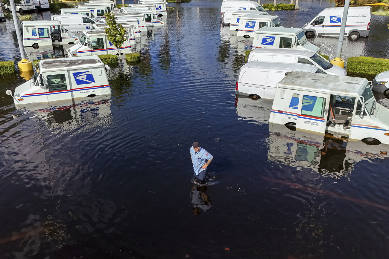 Un homme et des véhicules dans un terrain inondé