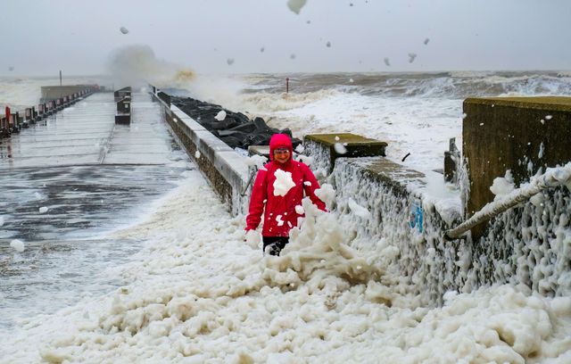 Une dame qui aime bien jouer avec sa vie est venue observer la tempête Bert qui a créé d’énormes vagues sur la côte du Dorset, à West Bay, dans le sud de l’Angleterre, le 24 novembre 2024. La marée haute et les vents forts ont créé de grandes quantités d’écumes.