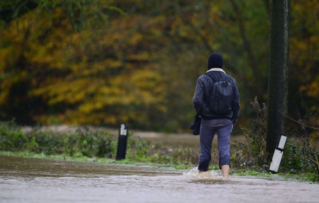 Un marcheur qui ne voulait pas abîmer ses chaussures, près de Crediton, dans le sud de l’Angleterre, où le fleuve Exe est en crue.