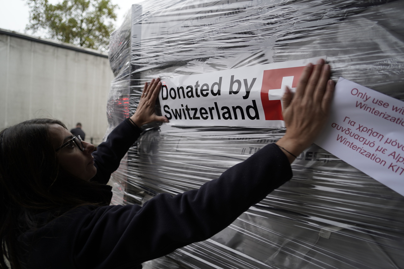 Une livraison d'aide humanitaire avec un écriteau "donation de la Suisse"