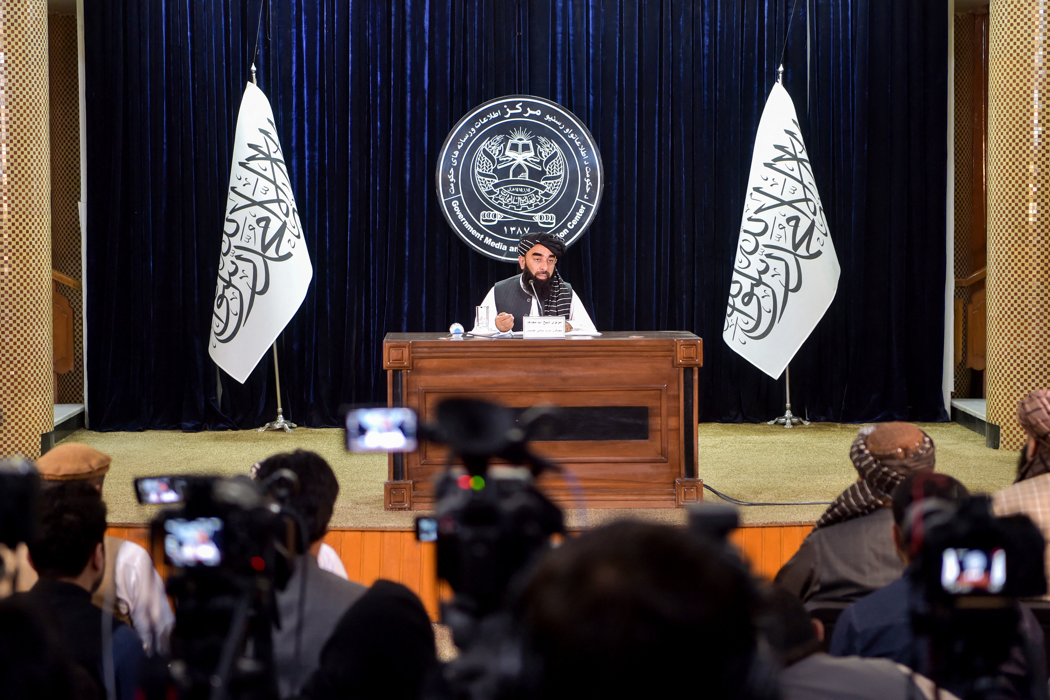 Un taliban assis face aux médias lors d'une conférence de presse.