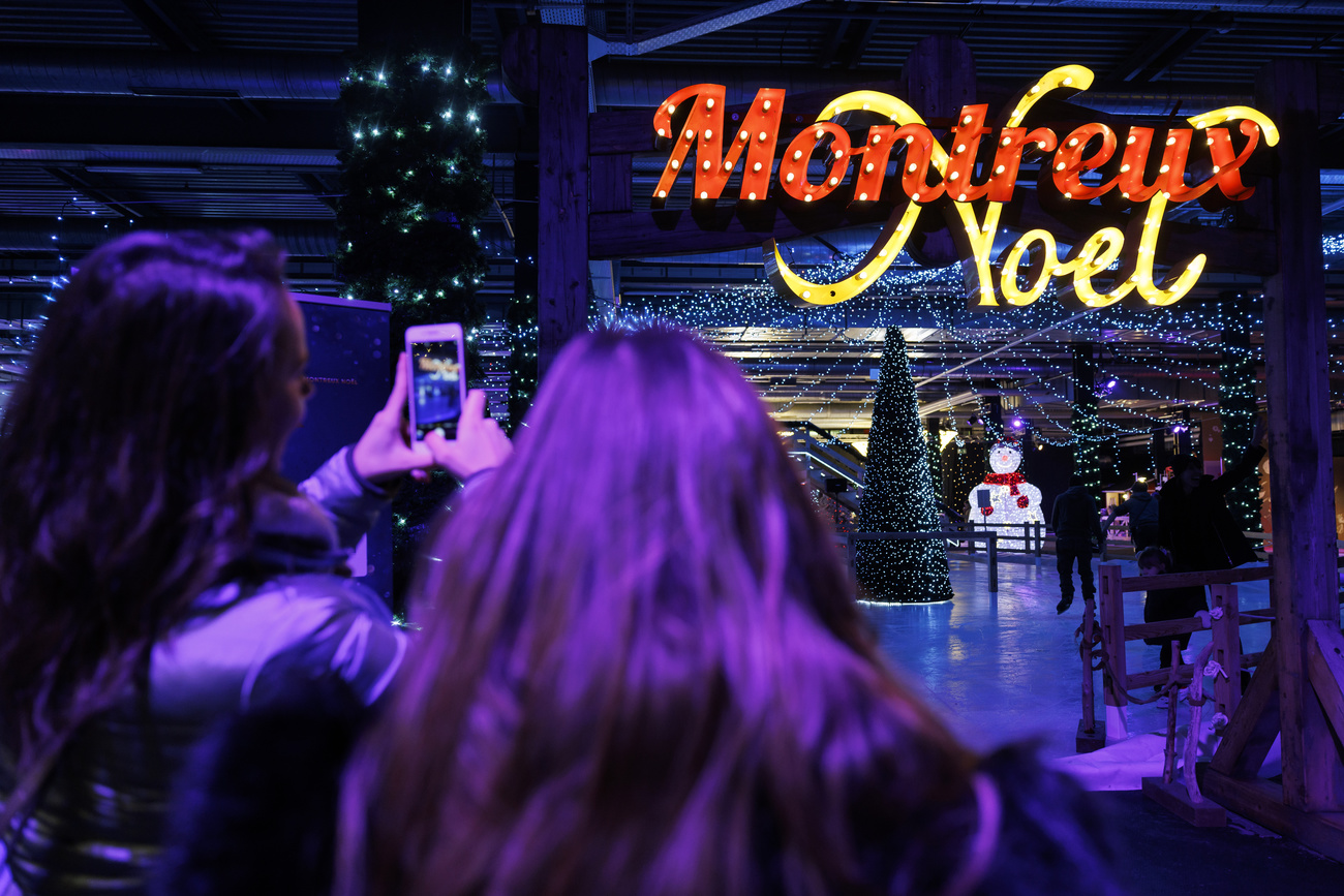 prennent en photos le logo "Montreux Noel" dans la patinoire "Light on Ice" lors du Marche de Noel ce vendredi, 26 novembre 2021 a Montreux. Entre les rives du lac Leman et le sommet des montagnes des Alpes, Montreux Noel propose plusieurs activites autour de son traditionnel Marche de Noel du 19 novembre au 24 decembre 2021. (KEYSTONE/Cyril Zingaro)