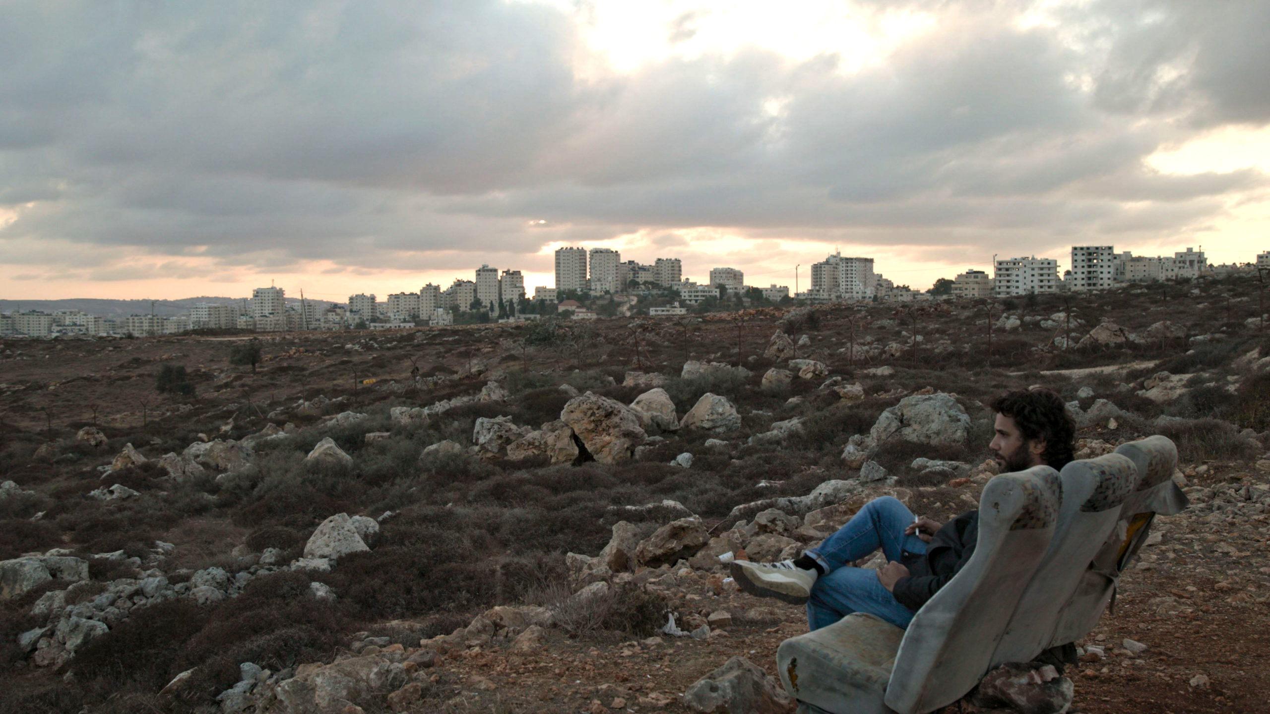 un homme devant une colonie israélienne en Cisjordanie