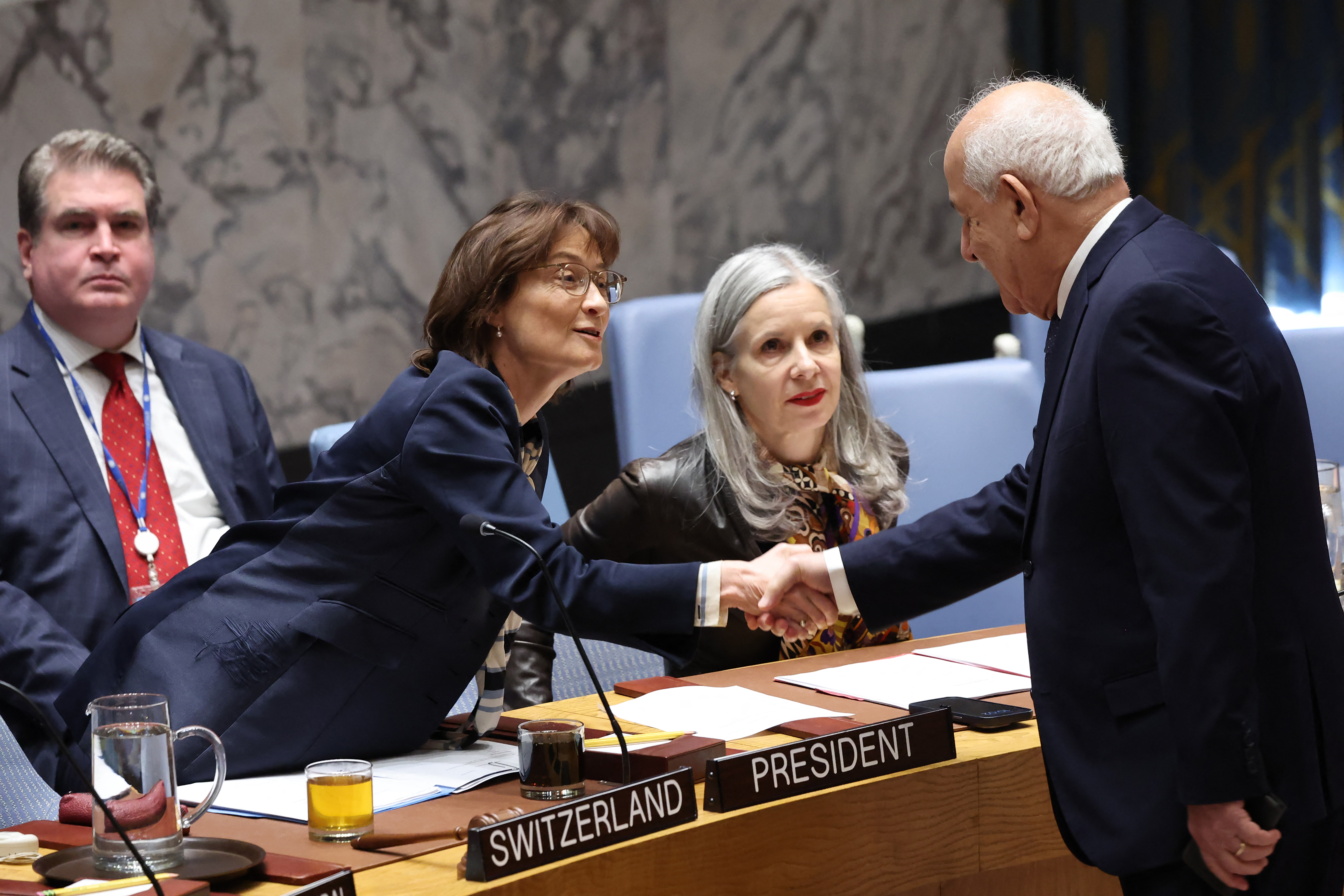 Pascale Baeriswyl, représentante permanente de la Suisse auprès de l'ONU et présidente du Conseil de sécurité pour le mois d'octobre, serre la main de Riyad Mansour, ambassadeur palestinien auprès de l'ONU, lors d'une réunion du Conseil de sécurité consacrée à la situation au Proche-Orient.