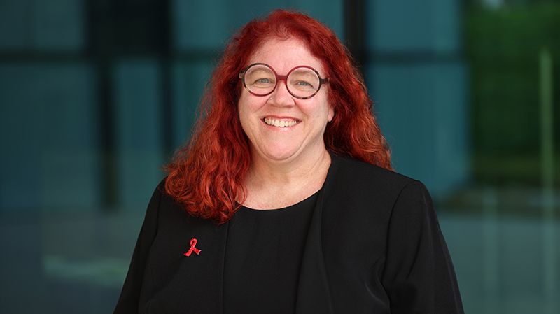 Femme souriante avec des lunettes rondes.