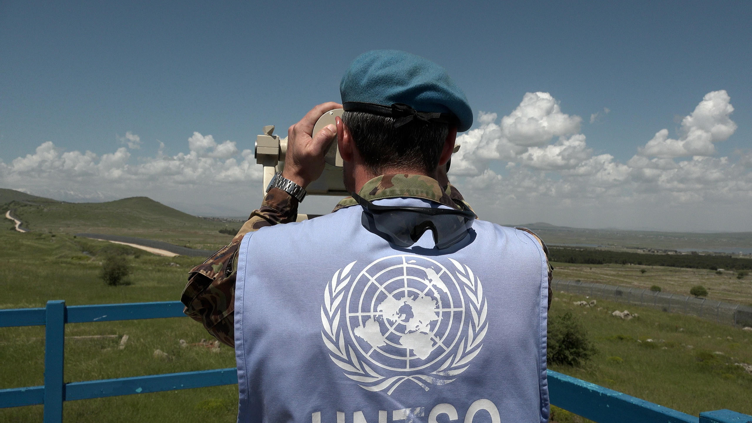 Soldat suisse de l ONU surveillant une zone avec des jumelles