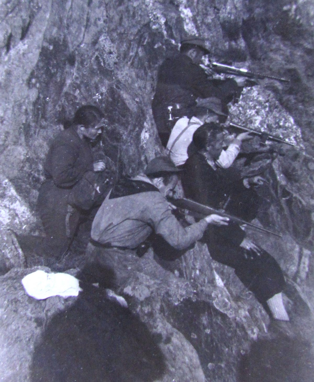 Groupe de partisans en train de tirer dans des montagnes.