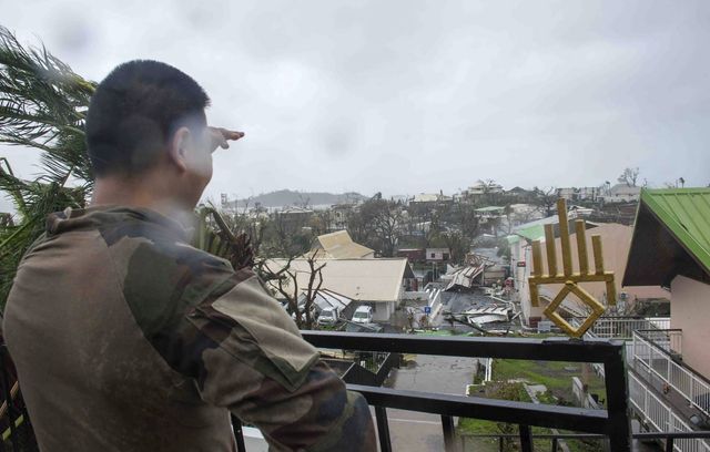 Soldat examinant les dégâts dans le territoire français de Mayotte dans l’océan Indien, après le passage du cyclone Chido.