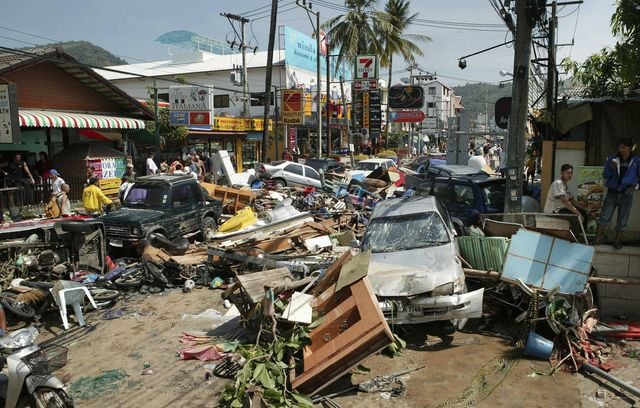 Une rue est jonchée de véhicules endommagés et de débris après que la zone ait été frappée par un raz-de-marée sur la plage de Patong à Phuket, en Thaïlande. Les vagues mesuraient plus de 30 mètres de haut, libérant une énergie équivalente à 23.000 fois la puissance de la bombe atomique d’Hiroshima.