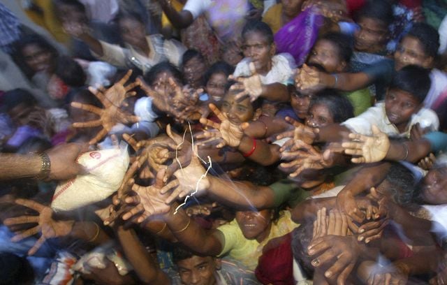 Les victimes du tsunami dans un camp de secours atteignent des paquets de riz distribués à Nagappattinam, dans l’État du Tamil Nadu, au sud de l’Inde, le vendredi 31 décembre 2004.