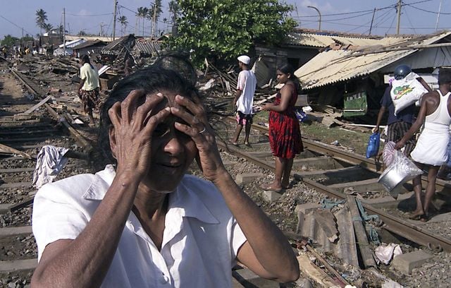 Une femme non identifiée pleure après que les raz-de-marée ont détruit sa maison dans les zones côtières de Colombo, au Sri Lanka, le dimanche 26 décembre 2004.