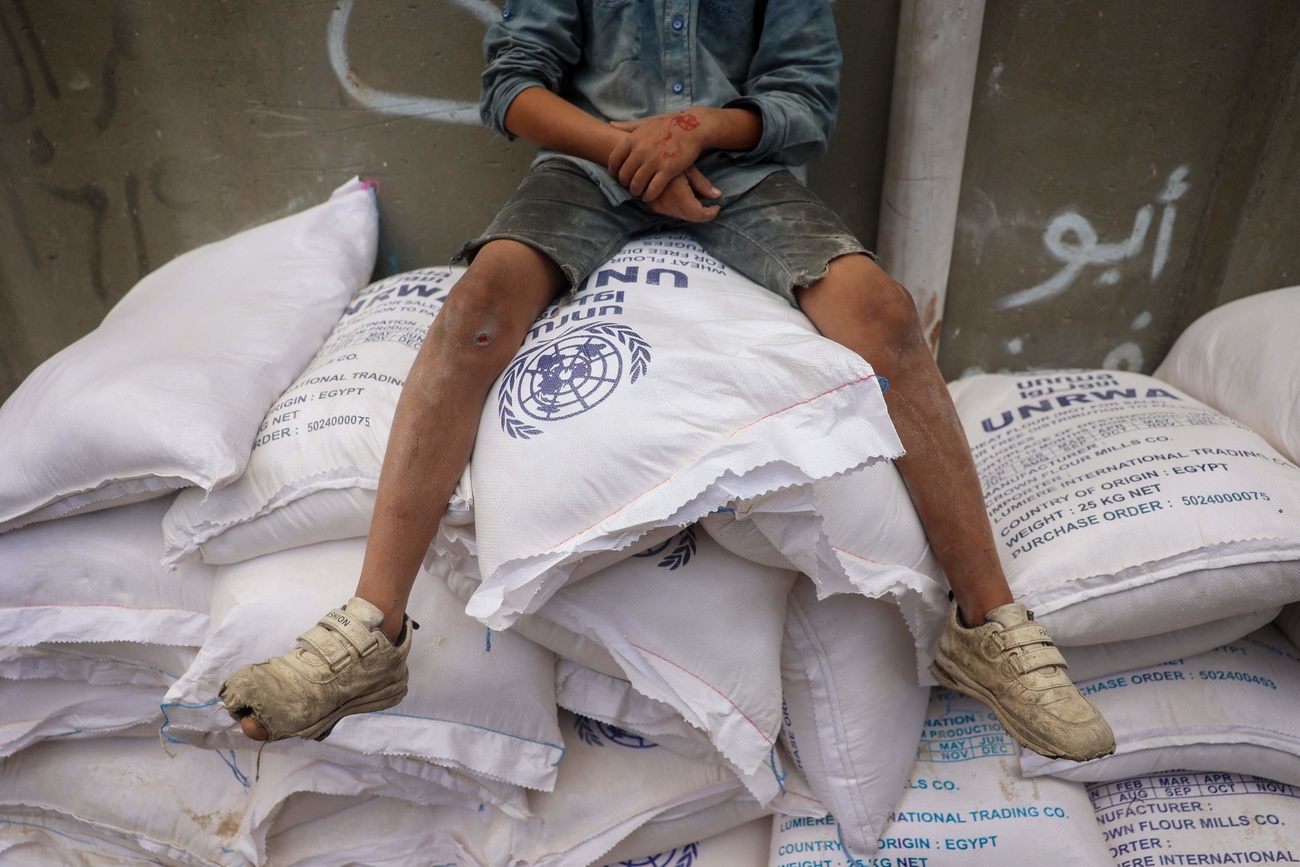 Un enfant sur des sacs de fournitures de l'UNRWA