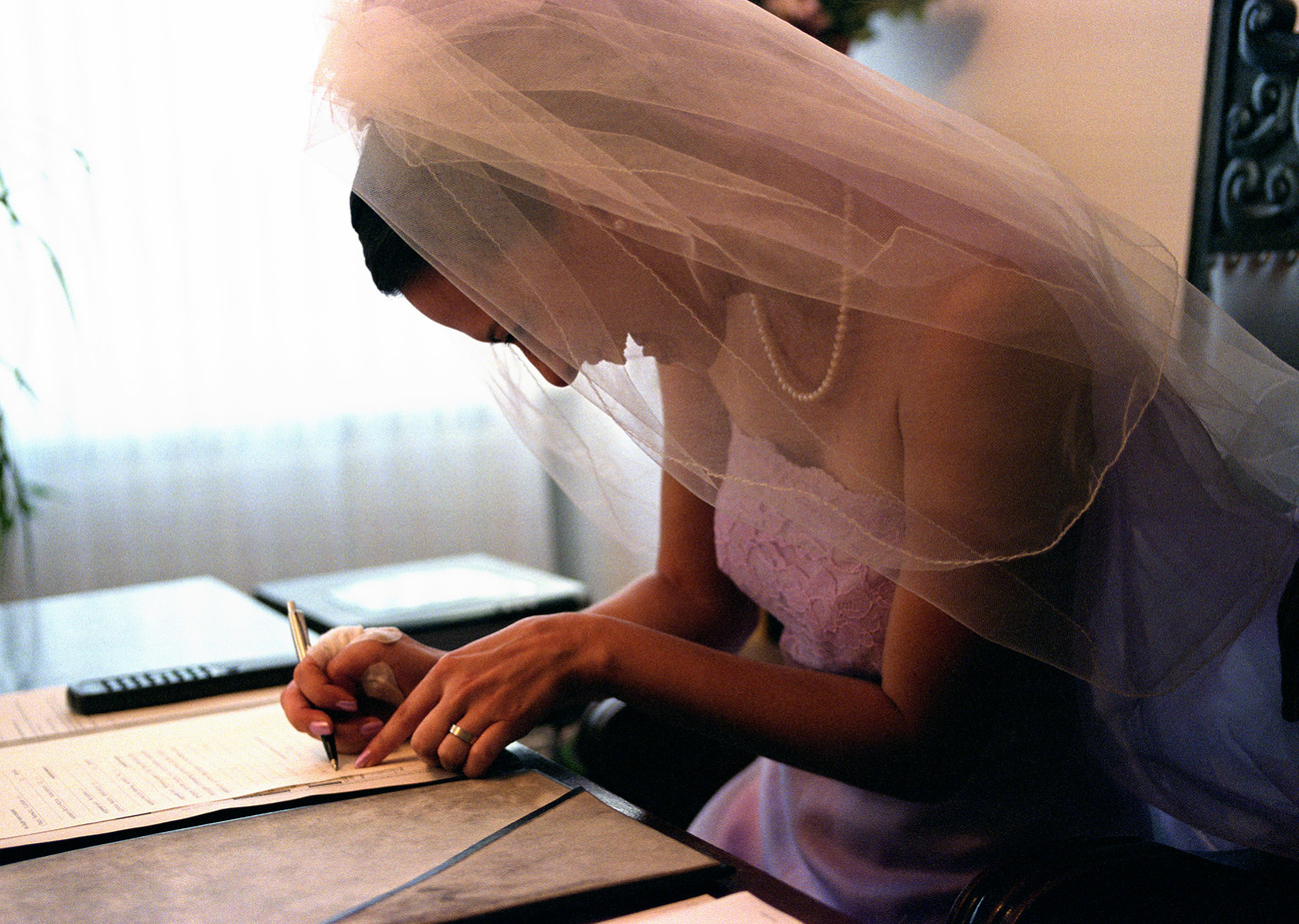 Mariée en train de signer l'acte de mariage.