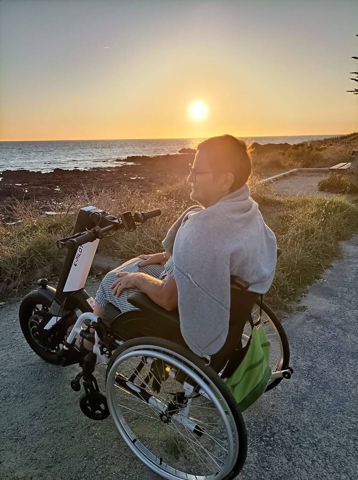 Grâce à cette troisième roue installée sur son fauteuil roulant, Jacqueline retrouve de l'autonomie et peut se promener seule, elle qui était passionnée de randonnée avant son accident.