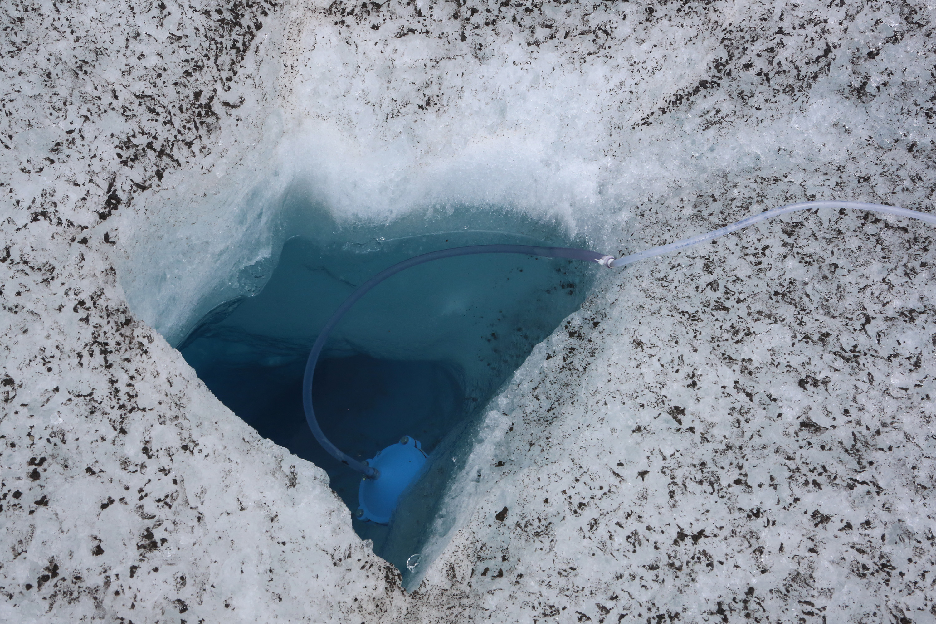 Instrument de mesure placé dans un trou creusé dans la glace.