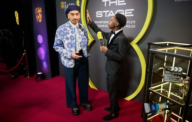 L’acteur Nabhaan Rizwan est arrivé sur le tapis rouge des BAFTA avec des fleurs. O.K. sur sa veste. Ce que semble valider le présentateur Jeriah Kibus.