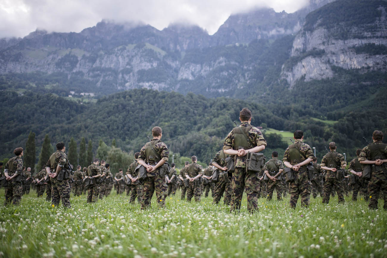 Soldats suisses en position de repos dans un pré