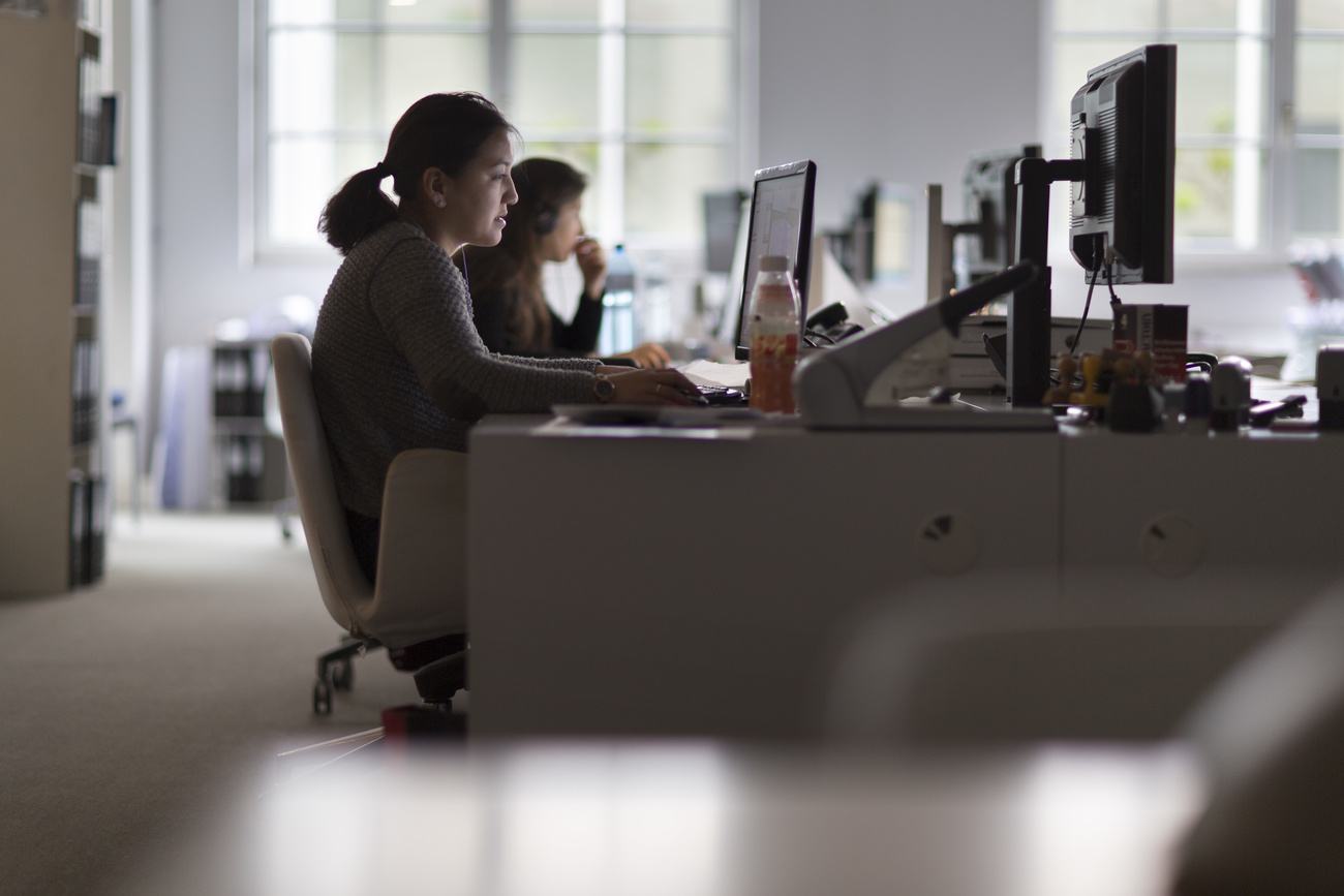 Deux femmes derrière des ordinateurs dans un bureau.