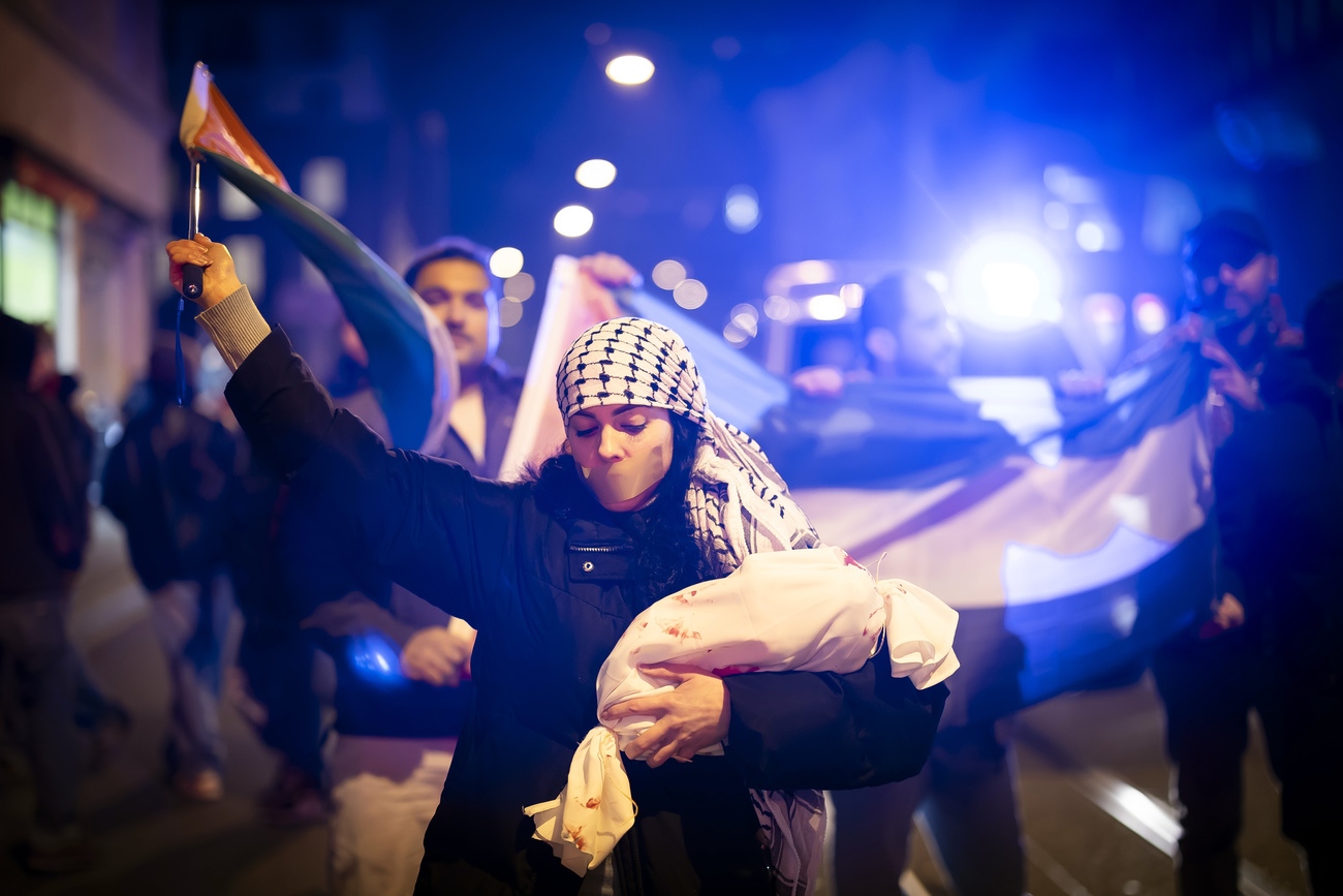 Une femme proteste avec un drapeau palestinien, en marge d'une veillée contre l'antisémitisme à Zurich.