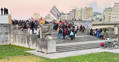 La police renforce son dispositif pour le MR à Liège : banderole des antifas et conteneurs pour fermer la rue.