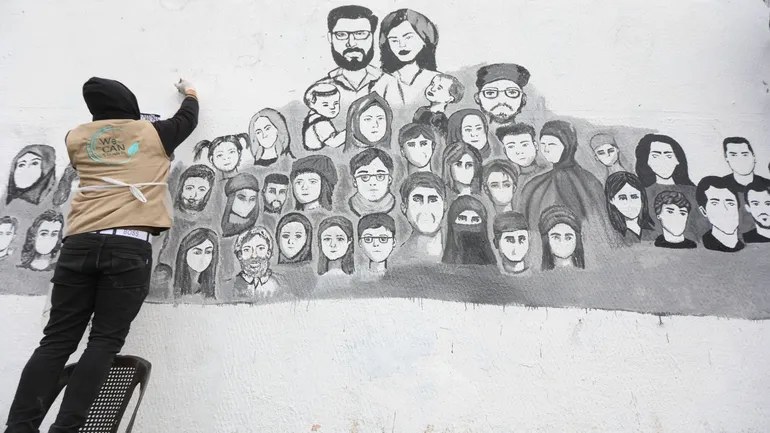 Damas, Syrie, 23 février 2025. Des artistes, familles de disparus et étudiants de l’Université des Beaux-Arts de Damas peignent les portraits des détenus du régime de la prison de Baath dont le sort reste inconnu.