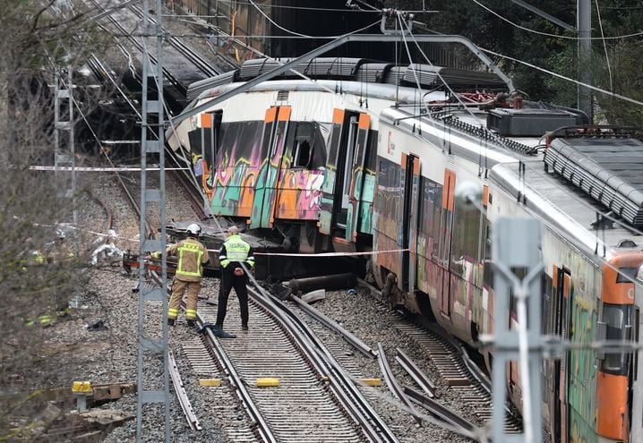 Les pompiers travaillent sur le site où au moins une personne est morte et cinq ont été grièvement blessées, mardi, lorsqu'un train de service régional est entré en collision avec un mur effondré.