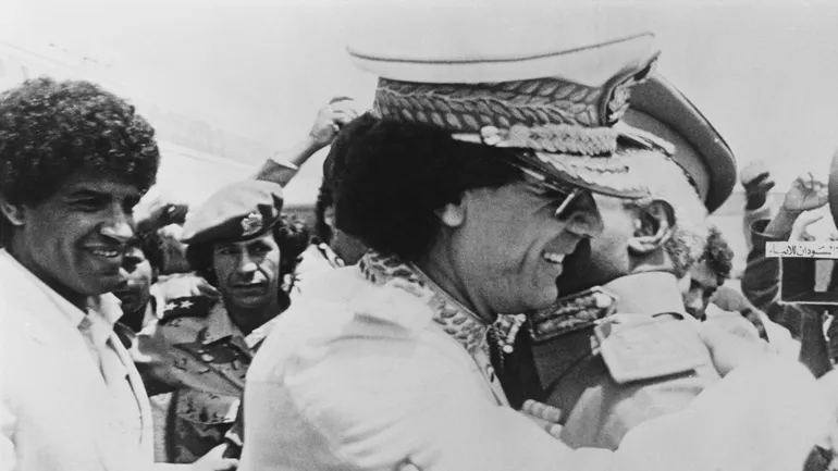 Mouammar Kadhafi accueilli par Abdel Rahman Swar al-Dahab lors de sa visite au Soudan, le 18 mai 1985. Abdallah Senoussi l’accompagne (à gauche).