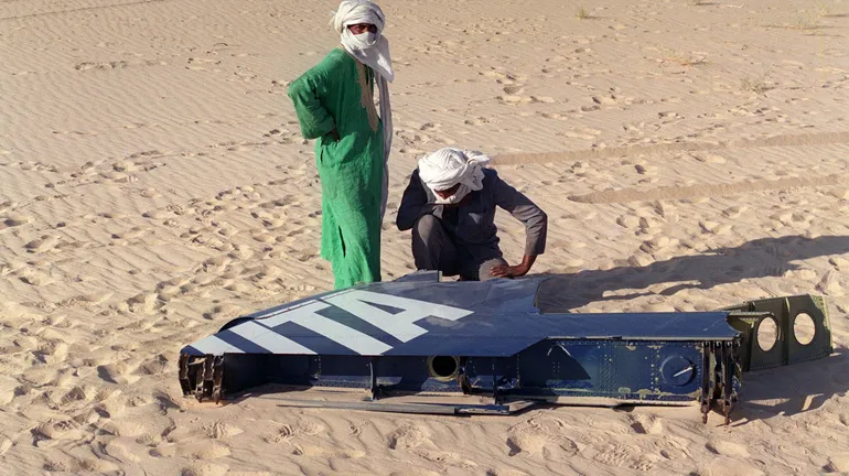 Deux Touaregs examinent des morceaux du DC-10 dans le désert du Ténéré, le 23 septembre 1989.
