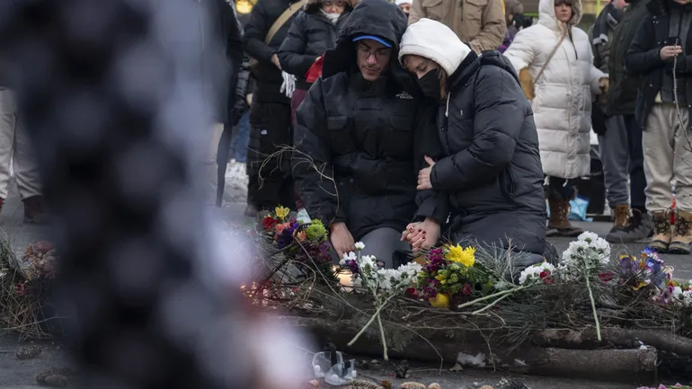 Des personnes pleurent dans le quartier où Alex Pretti, 37 ans, a été abattu par des agents fédéraux de l'immigration plus tôt dans la journée à Minneapolis, dans le Minnesota, le 24 janvier 2026. 