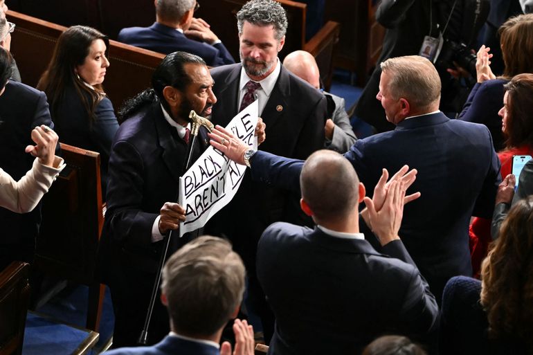Le représentant américain Al Green, démocrate du Texas, quitte la salle en brandissant une pancarte sur laquelle on peut lire "Les Noirs ne sont pas des singes" dans la Chambre des représentants du Capitole à Washington, DC, le 24 février 2026.
